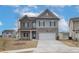 Two story home with gray siding and brick accents, two car garage, and a landscaped yard at 608 Somerset Ct, Loganville, GA 30052