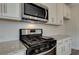 Modern kitchen with stainless steel appliances and granite countertops at 608 Somerset Ct, Loganville, GA 30052