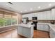 Modern kitchen with white cabinets, stainless steel appliances, and a large island at 11302 Musette Cir, Alpharetta, GA 30009