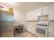 White kitchen with ample cabinetry, gas stove and stainless steel refrigerator at 70 E Honeysuckle Ln, Carrollton, GA 30116