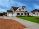 Two-story house with gray siding, three-car garage, and grassy yard at 1482 Stephens View Dr, Loganville, GA 30052