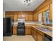 Efficient kitchen offering wood cabinets and black appliances at 5711 Rally Ct, Rex, GA 30273