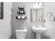 Simple bathroom with white pedestal sink, toilet, and a framed mirror at 1552 Mosaic Way, Smyrna, GA 30080