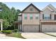Two-story townhome with neutral brick exterior, two-car garage, and landscaping at 5531 Radford Loop, Fairburn, GA 30213