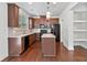 Kitchen with dark brown cabinets, granite island, and stainless steel appliances at 5531 Radford Loop, Fairburn, GA 30213