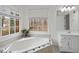 Relaxing bathroom with soaking tub, double vanity, and window at 308 Mainsail Ln, Woodstock, GA 30189