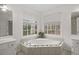 Spa-like bathroom featuring a corner soaking tub and double sinks at 308 Mainsail Ln, Woodstock, GA 30189