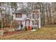 Two-story house with red accents, driveway, and mature trees in the yard at 308 Mainsail Ln, Woodstock, GA 30189