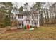 Two-story house with red accents, driveway, and mature trees in the yard at 308 Mainsail Ln, Woodstock, GA 30189