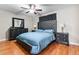 Main bedroom with tufted headboard bed and hardwood floors at 6700 Roswell Rd # 21H, Atlanta, GA 30328