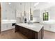 Modern kitchen with white cabinets, large island, and gold accents at 324 Mont Harmony Sw Rd, Powder Springs, GA 30127