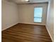 Spacious bedroom featuring wood-look floors and a window with blinds at 5157 Roswell Rd # 9, Atlanta, GA 30342