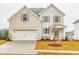 Two-story house with light beige vinyl siding, a white garage door, and landscaping at 1700 Fulmont Cir, Mableton, GA 30126