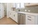 Modern kitchen with white cabinets, a stainless steel dishwasher, and gray backsplash at 1700 Fulmont Cir, Mableton, GA 30126