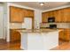 Open kitchen island with granite countertops and wood cabinets at 2565 Maple Leaf Ter, Cumming, GA 30041