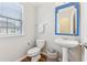 Small powder room with pedestal sink, toilet, and blue mirror at 3077 Eastbrook Sw Ter, Atlanta, GA 30331