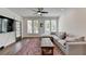 Open living area with hardwood floors, sectional sofa, and a large TV at 129 Devore Rd # 205, Alpharetta, GA 30009