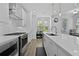 Modern kitchen with white cabinets, stainless steel appliances, and quartz countertops at 3227 Bartee Walk, Suwanee, GA 30024