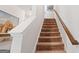 Carpeted staircase with wooden railing and wall art at 1267 Carbon Ct, Atlanta, GA 30316