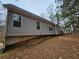 Gray siding home with a slight incline in the backyard at 4671 W Lake Se Dr, Conyers, GA 30094