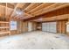 Unfinished basement with high ceilings, ample storage shelving, and a large garage door at 3581 Camelot Way, Loganville, GA 30052