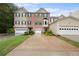 Three-story brick townhome with two-car garage and small lawn at 450 Abbotts Mill Dr # 54, Duluth, GA 30097