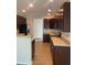 Kitchen with dark wood cabinets, tile backsplash, and light flooring at 539 Greyhawk Way, Fairburn, GA 30213
