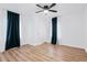 Bright bedroom with ceiling fan, hardwood floors, and dark teal curtains at 5125 Kent Rock Rd, Loganville, GA 30052