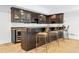 Basement wet bar with dark wood cabinets and granite countertop at 6092 Carlisle Ln, Alpharetta, GA 30022