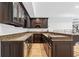 Long view of a basement bar with dark wood cabinets at 6092 Carlisle Ln, Alpharetta, GA 30022