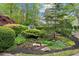 Landscaped entryway with lush greenery and stone accents at 6092 Carlisle Ln, Alpharetta, GA 30022