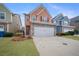 Two-story townhome with peach-colored siding, stone accents, and a two-car garage at 7167 Rigel Sw Bnd, Atlanta, GA 30331