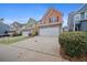 Two-story townhome with peach-colored siding, stone accents, and a two-car garage at 7167 Rigel Sw Bnd, Atlanta, GA 30331