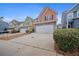 Two-story townhome with peach-colored siding, stone accents, and a two-car garage at 7167 Rigel Sw Bnd, Atlanta, GA 30331