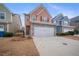 Two-story townhome with peach-colored siding, stone accents, and a two-car garage at 7167 Rigel Sw Bnd, Atlanta, GA 30331