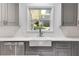 Modern farmhouse kitchen with white sink and gray cabinets at 7077 Milam Rd, Winston, GA 30187