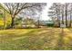 Large backyard with mature trees and a storage shed at 6685 Buckhurst Trl, Atlanta, GA 30349