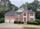 Brick house with two-car garage and landscaping at 1800 Riverglen Dr, Suwanee, GA 30024