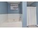Soaking tub with shower in a blue bathroom at 3112 Spicy Cedar Ln, Lithonia, GA 30038