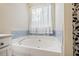 Bathroom featuring a large garden tub and window at 312 Magnolia Springs Trce, Canton, GA 30115