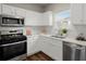 White kitchen with stainless steel appliances and a corner sink at 7792 Newbury Dr, Jonesboro, GA 30236