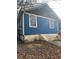 Side view of blue house with wooden steps and landscaping at 271 Andrew Hairston Nw, Atlanta, GA 30314