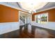 Formal dining room featuring hardwood floors and an orange accent wall at 2571 Se Ebenezer Rd, Conyers, GA 30094