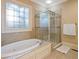 Luxurious bathroom with soaking tub, walk-in shower, and stained glass window at 1255 Mcminn Way, Snellville, GA 30078