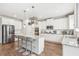 Modern kitchen with white cabinets, granite island, and stainless steel appliances at 806 Relic Rdg, Hampton, GA 30228