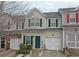 Tan townhome with green shutters, white garage doors, and landscaping at 230 Valley Xing, Canton, GA 30114