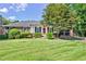 Brick ranch home with red door, lush lawn, and mature trees at 2202 Allaire Ln, Atlanta, GA 30345