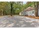 Large gravel driveway and expansive backyard with mature trees at 159 Forest Ave, Social Circle, GA 30025