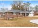 Brick ranch house with a two-car garage and landscaped yard at 1283 Woodleigh Sw Rd, Marietta, GA 30008