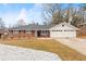 Brick ranch house with a two-car garage and landscaped yard at 1283 Woodleigh Sw Rd, Marietta, GA 30008